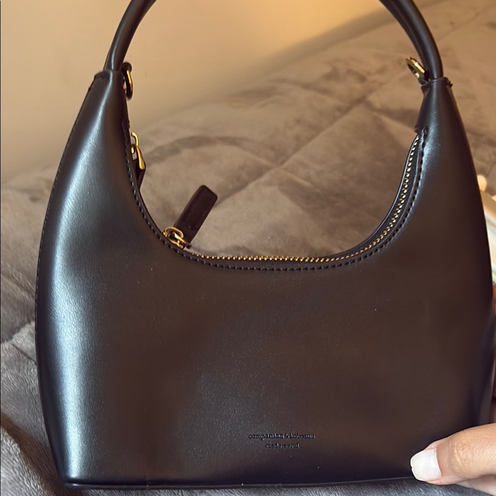 Sleek Black and Gold Shoulder Bag with Curved Silhouette